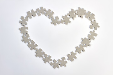 Heart frame made from puzzles. Shape of heart from jigsaw puzzles over white background. Happy Valentines Day.