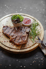 Grilled steak served on wooden board. Top view