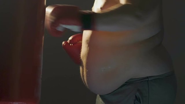 Overweight man fighting with extra weight actively training in gym and dieting
