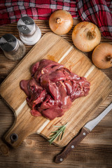 Raw chicken liver on cutting board.
