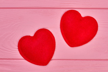 Valentines Day background with red fluffy hearts. Two felt hearts on colorful wooden background. Happy Saint Valentines Day.