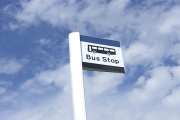 Bus stop sign sky background blue white clouds view below information public transport school old age pensioner travel free coach post uk 