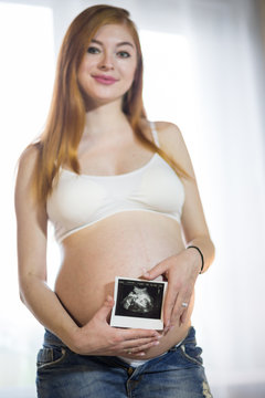 pregnant woman showing a picture of an ultrasound scan