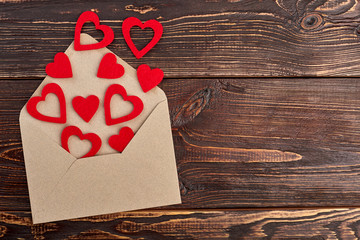 Red paper hearts and evelope, top view. Opened envelope and hearts, copy space. Valentines holiday concept.