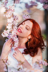 Naklejka premium portrait of a woman at a flowering tree