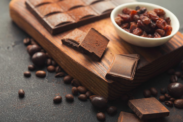 Crushed chocolate pieces and raisons on gray background