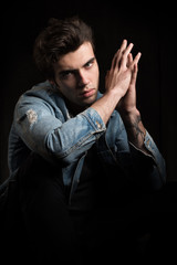 A courageous portrait on a black background. Young handsome man posing and looking at camera