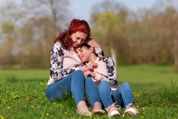 mother and daughter sitting together on the lawn