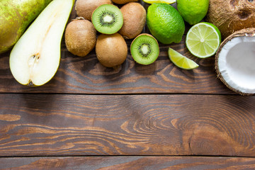 ripe fruit pear kiwi lime coconut on a wooden table top with a place for inscription