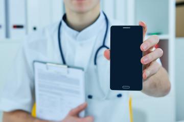 Male doctor's hand showing a blank smart phone screen.