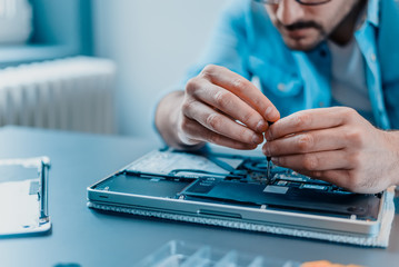 Close-up of laptop disassembling in repair shop.