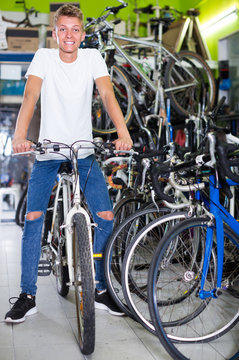 smiling male sitting on bicycle in the store