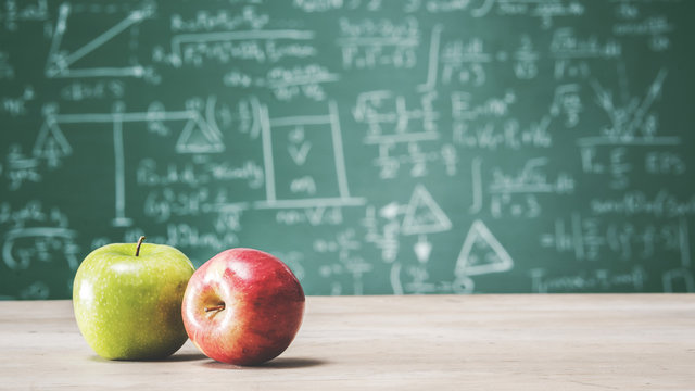 Back to school concept with apples in front of green chalk board