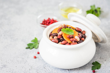 Slow cooker beans in a pot on concrete background. Selective focus, space for text. 