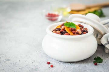 Vegan spicy beans in a pot on concrete background. Selective focus, space for text. 