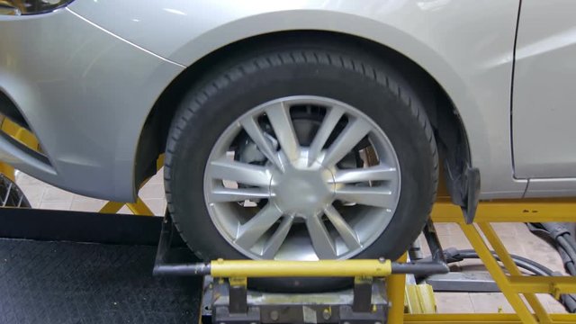 equipment in laboratory is shaking a wheel of new automobile in car plant