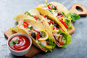 Traditional Mexican tacos with meat and vegetables on gray background .