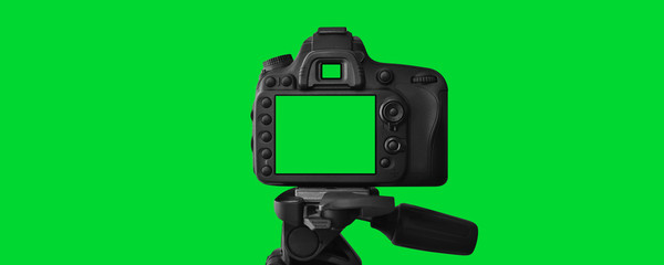Naklejka premium The Dslr camera with empty screen on the tripod, isolated on green background. The chromakey. Green screen.
