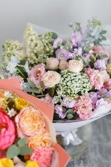 two bouquet of beautiful flowers on gray table. Floristry concept. Spring colors. the work of the florist at a flower shop. Vertical photo