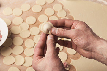 Preparing dumplings with meat, forming small ravioli