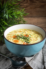 Broth - chicken soup in a blue bowl.