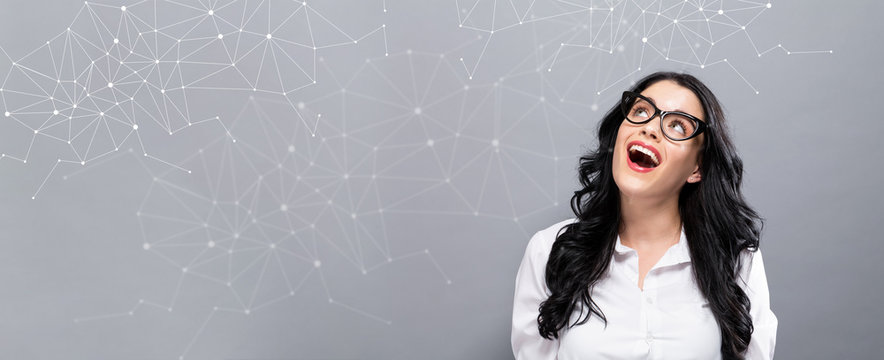 Fototapeta Links with happy young businesswoman on a gray background