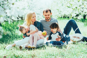 Happy family mom dad and kids daughter and son having fun outdoor in park smiling and laughing. Lifestyle Emotions Relationship Love