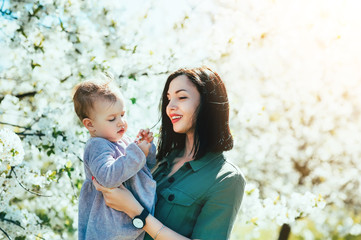 Happy loving family mom and child girl kissing and hugging outdoor in blossom park. Mother day, Relationship Love Values Tenderness Lifestyle