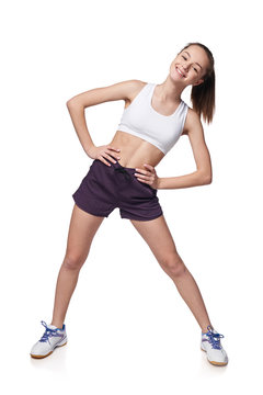 Full length teen girl smiling doing fitness exercises, isolated on white background