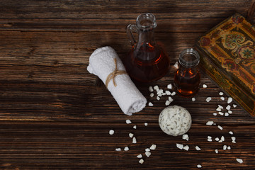 old metal case for cosmetics, herbal ball for bathing and natural body oils next to a white towel with free space for text