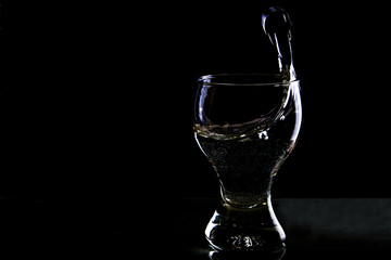 Splash of water in a glass on a black background