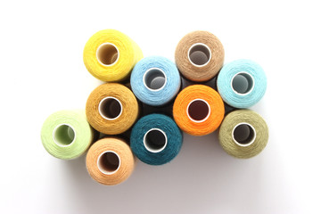 sewing thread of different colors isolated on white. top view  