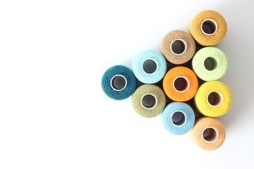 sewing thread of different colors isolated on white. top view  