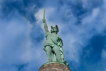 Fototapeta premium Hermannsdenkmal auf Steinsockel vor sonnigem, blauem Himmel