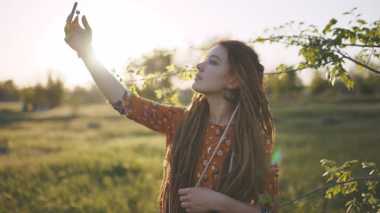  beautiful hippie woman with dreadlocks in the woods at sunset having good time outdoors