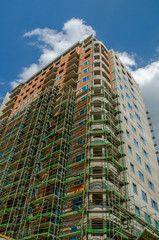 High rise building under construction. big building construction site against blue sky with white cloud. Industrial background