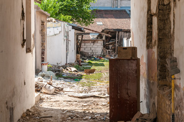 Interior remains of hurricane or earthquake disaster damage on ruined old house in the city with collapsed walls, roof and bricks with selective focus