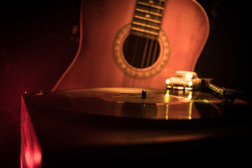 Vintage vinyl record playing on player and acoustic guitar on background with fire orange smoke. Blues concept. With Toy car