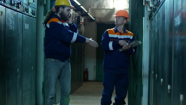 Two electricians at the substation. Employees shake hands