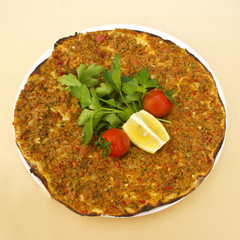Turkish tortilla pita with minced meat and spices, decorated with cherry tomatoes and parsley leaves.