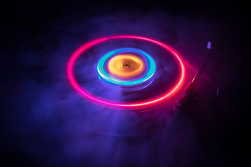 Turntable playing vinyl with glowing abstract lines concept on dark background