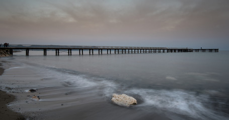 Seascape with jetty during a dramatic cloudy sunsrise