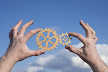 two hands of businessmen connect gears, pieces of a puzzle. The concept of a business idea. Cooperation, strategy, creativity, innovation, teamwork, industry.