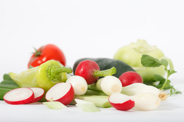 Set of fresh vegetables on a white background. Red tomato and radish and green onion, kohlrabi, pepper and cucumber, 
