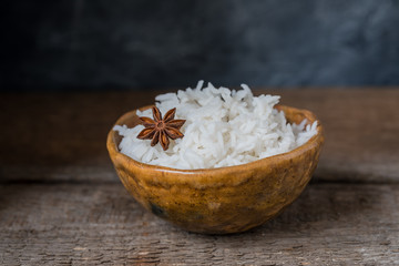 Bowl with white rice on the wooden background, wabi sabi style