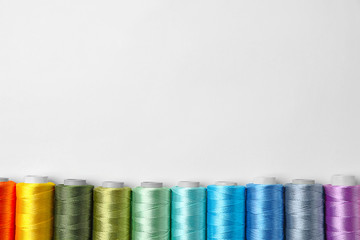 Color sewing threads on white background, top view