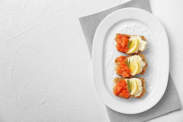 Plate of tasty sandwiches with fresh sliced salmon fillet on table, top view