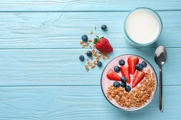 Gordijnen Tasty breakfast with yogurt, berries and granola on wooden table, top view © New Africa
