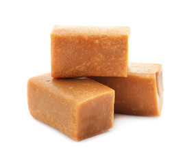 Delicious caramel candies on white background