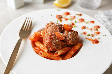 Delicious pasta with meatballs and tomato sauce on plate, closeup